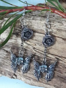 Earrings with surgical steel hooks featuring skull butterfly and rose metal alloy pieces